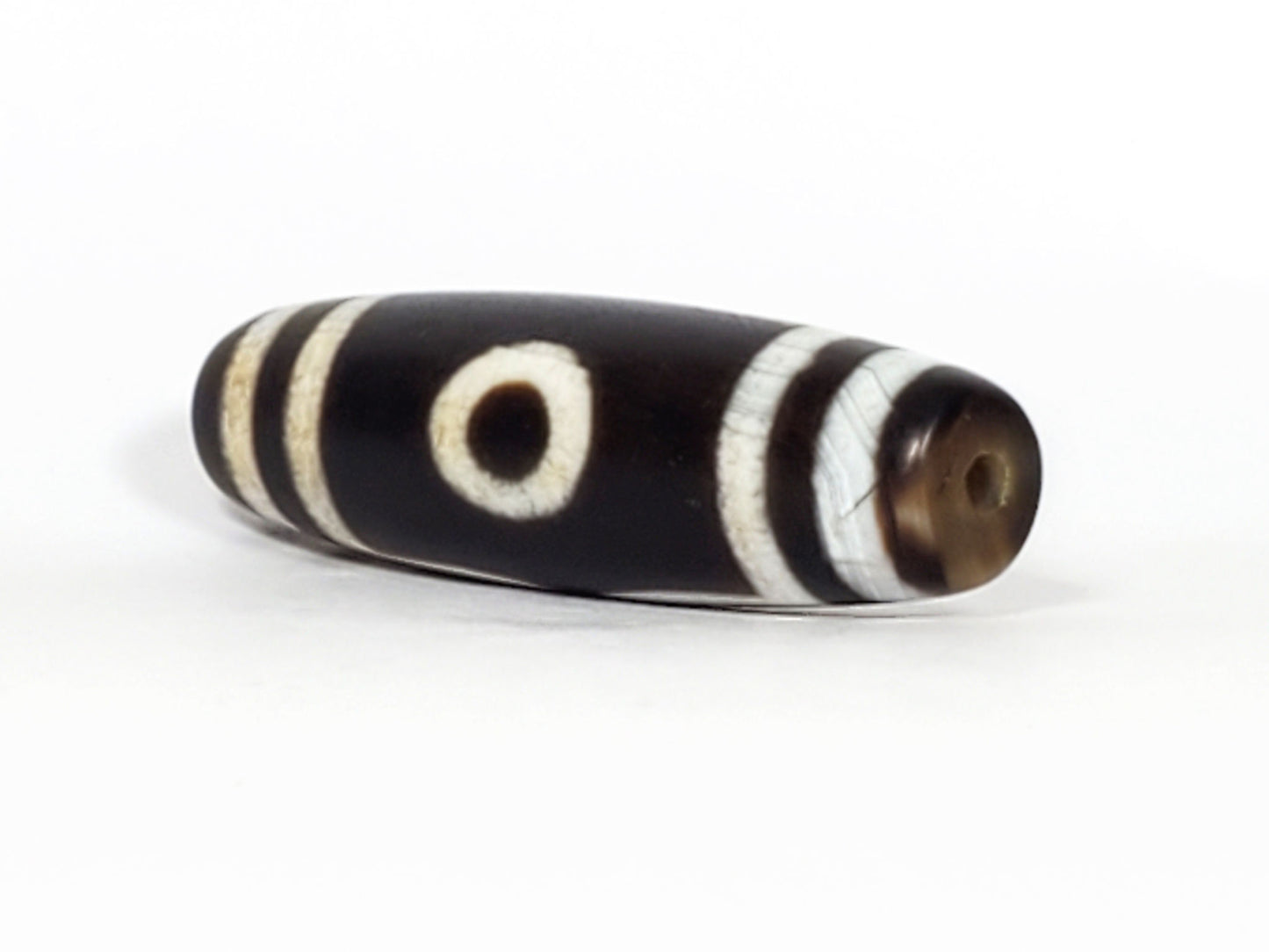 N-070226-3E dzi bead, diagonal view showing drill hole and single eye face, black agate, unretouched.