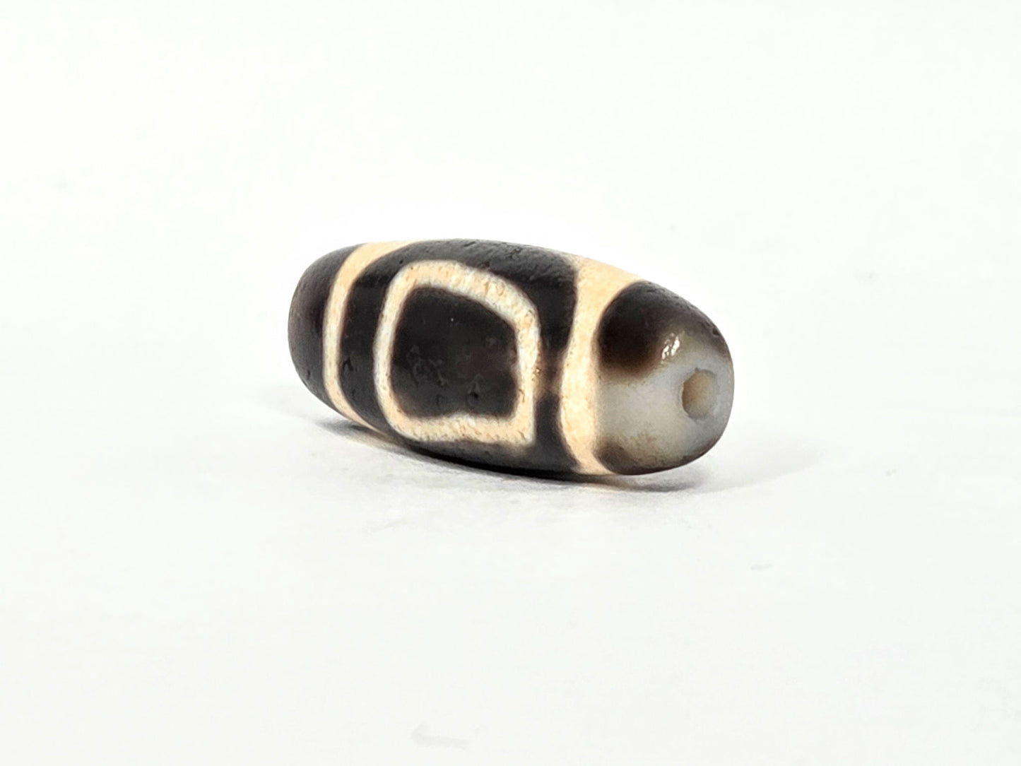 V-071326-HE pale cream-grey end cap, small centred drill hole, contrasts dark body, asymmetric end cap, unretouched