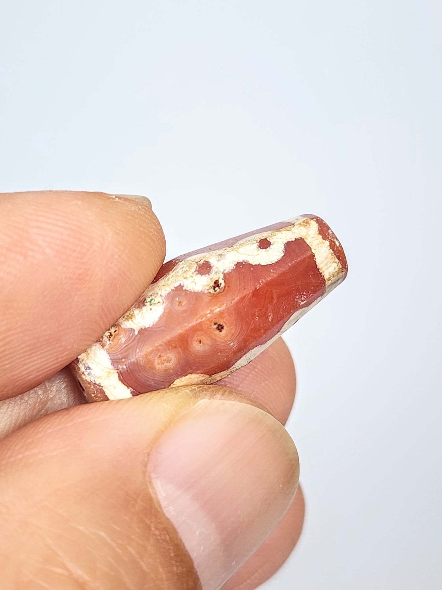 Ac-050725-LKBS bloodspot macro, 4–5 sub-surface cinnabar dots in carnelian zone, 2 pinholes visible, unretouched