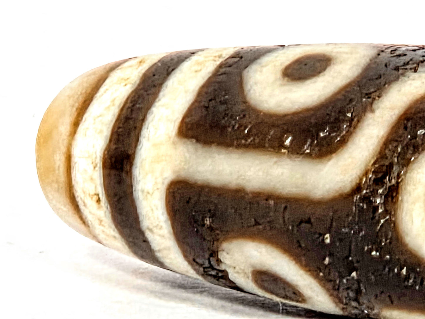 Ac-070926-9E ancient nine eye dzi close-up opposite end cream agate end cap dark brown stripe detail unretouched