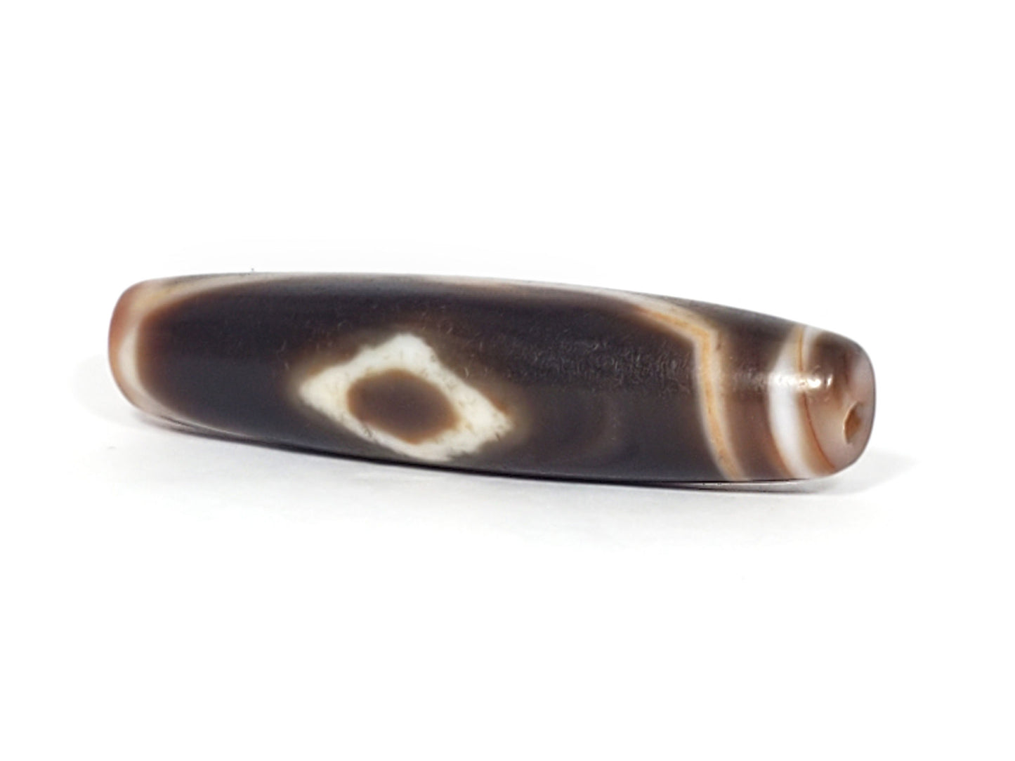 At-061926-3DE2 angled tip A, elongated fusiform form, warm reddish-brown end cap, unretouched