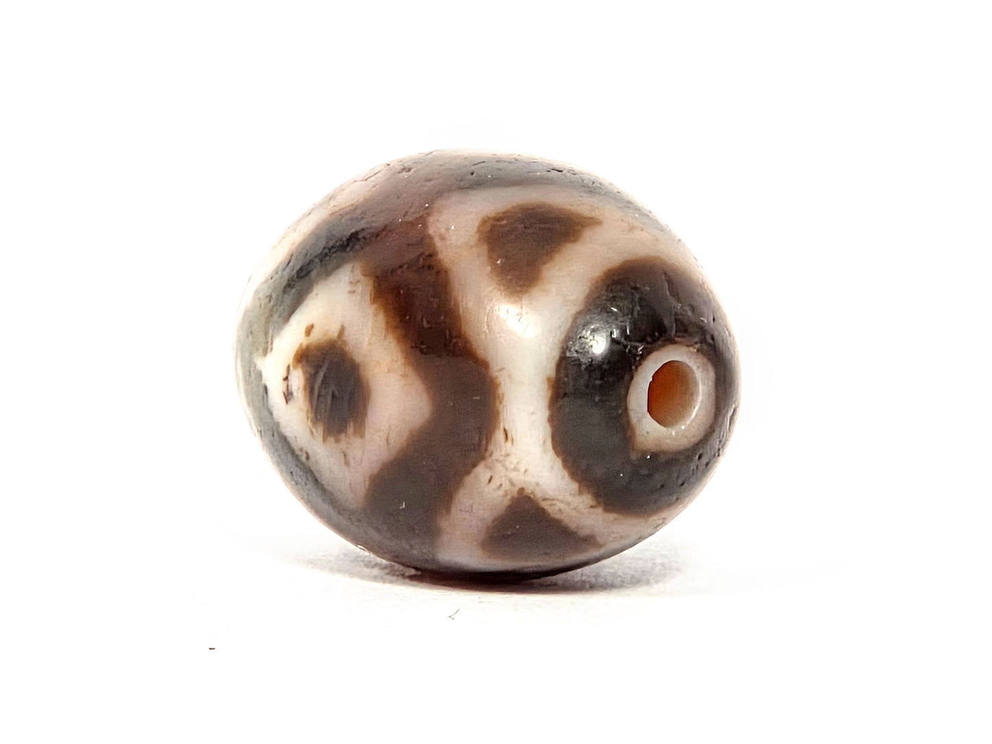 V-072226-3ETT drill-end angle A — warm reddish-orange drill opening, cool grey pole zone, cream body, unretouched.