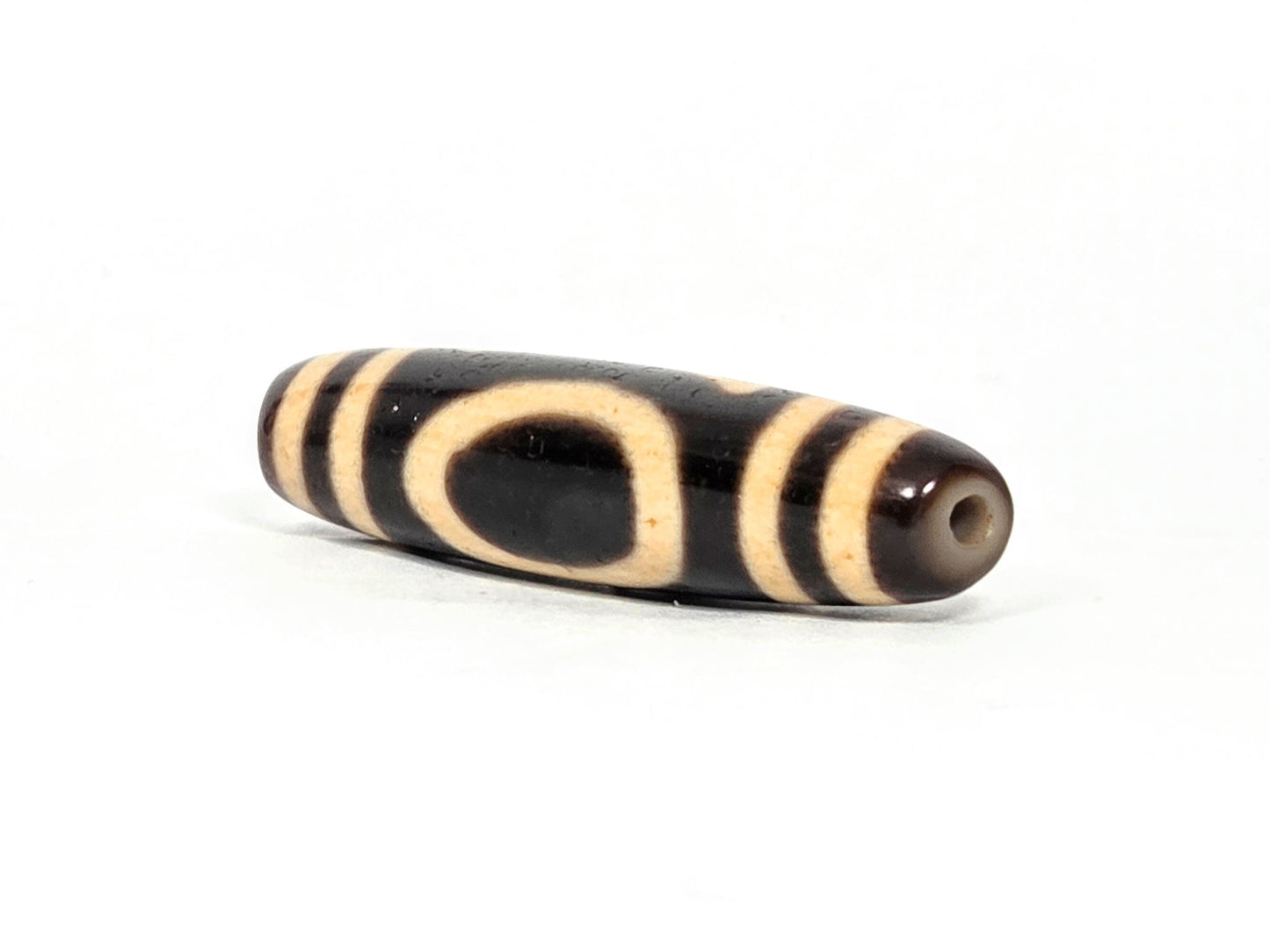 At-071326-HE sharper tapered drill-hole end, warm brown-grey cap, small clean hole, Heaven Earth oval visible, unretouched