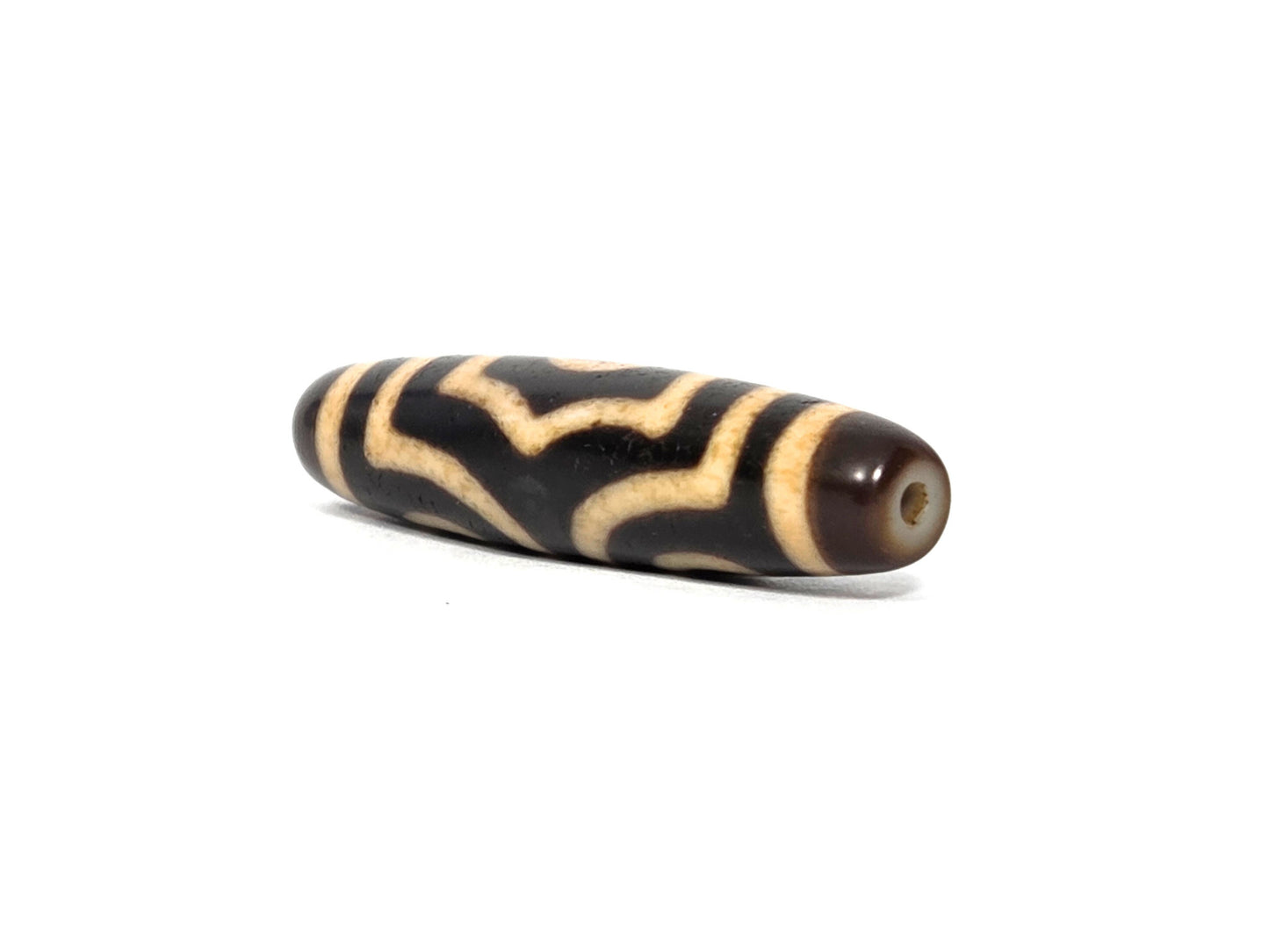 At-090226-3E2 antique three eye dzi dark agate angled view drill end cap warm reddish-brown, unretouched