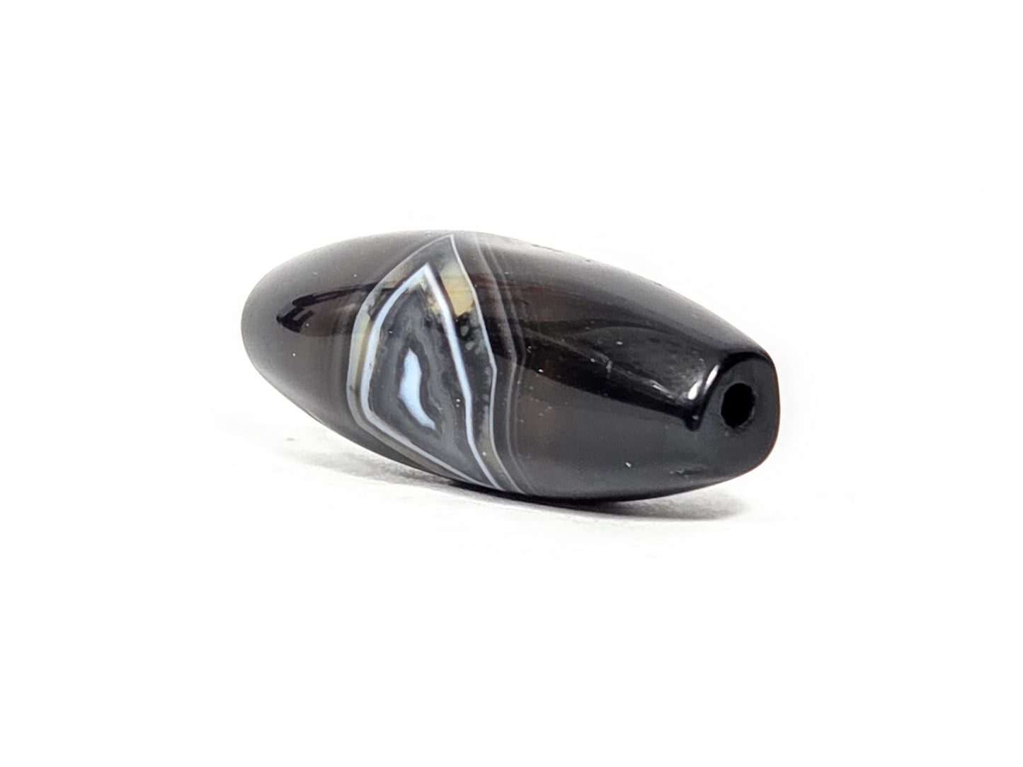 N-N-071126-1E-OLV3 three-quarter, narrow tapered drill-hole end, banding zone visible on body, unretouched