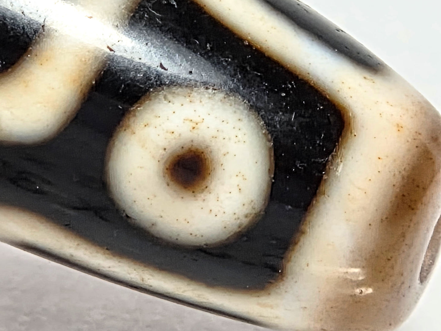 At-070626-9E2 macro, cinnabar micro-dots in cream eye zone, sparse scattered distribution, pitch-black ground, unretouched