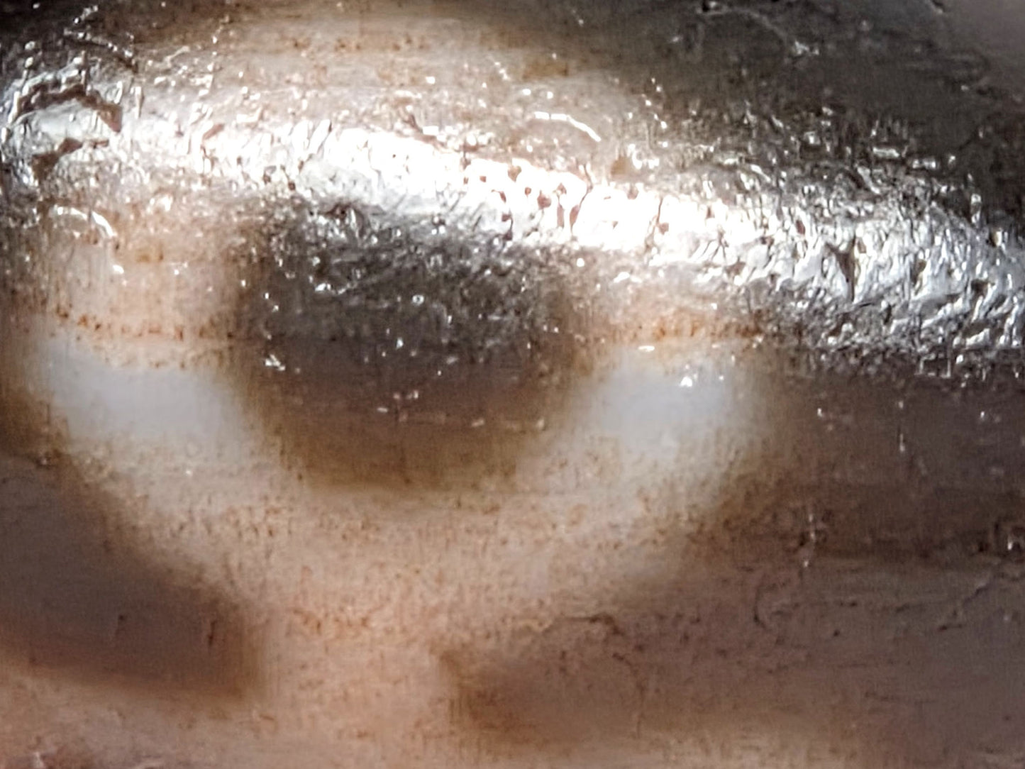 V-071426-BNF macro 2 — cinnabar speckling around eye ring boundary zone, warm cream ground, unretouched.