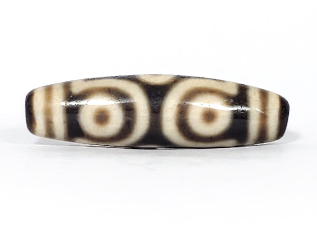 Authentic ancient Tibetan dzi bead with six-eye pattern on Himalayan agate — symbol of luck and fortune