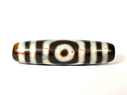 Close-up of genuine cinnabar bloodspots on an authentic antique Tibetan dzi bead — Ancient Dzi Shop