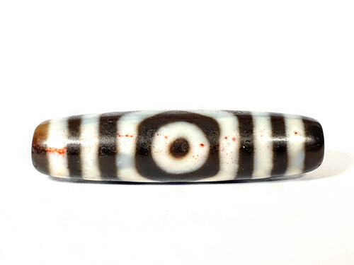 Ancient Tibetan three-eye dzi bead with extreme cinnabar bloodspots, vivid red inclusions across cream agate zones, dark brown ground, unretouched, Ancient Dzi Shop