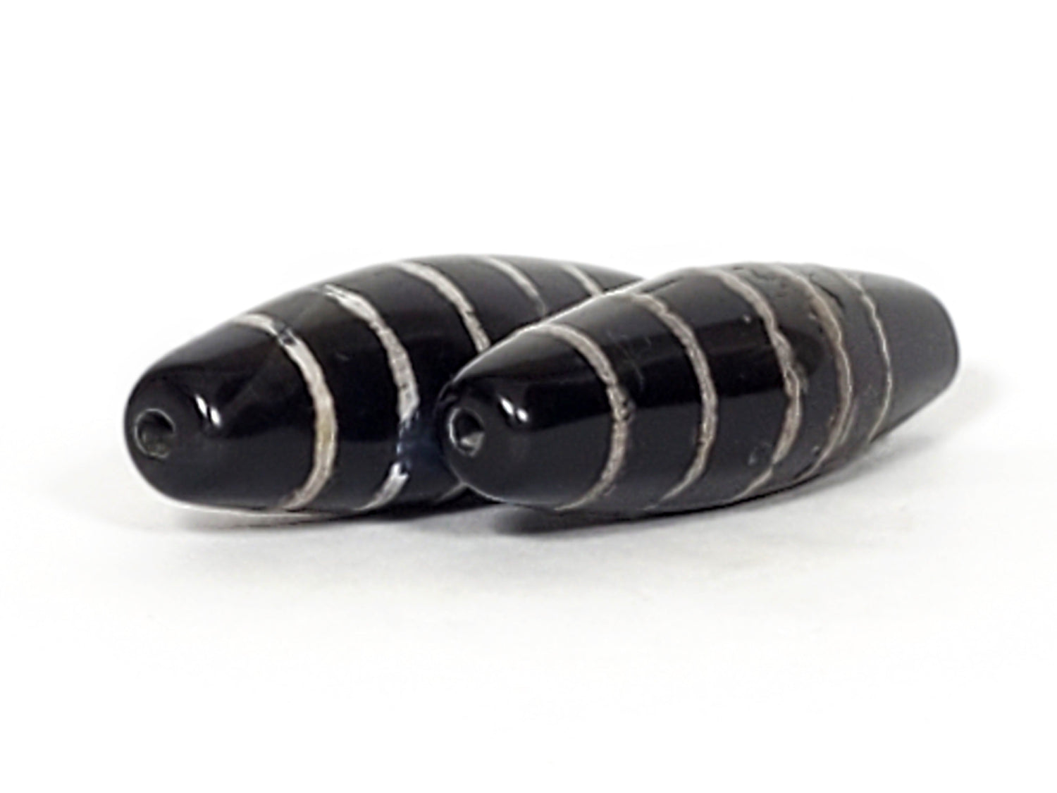 Authentic ancient black striped Dzi bead pair - powerful Tibetan protection talismans with century-old patina and sacred eye patterns.