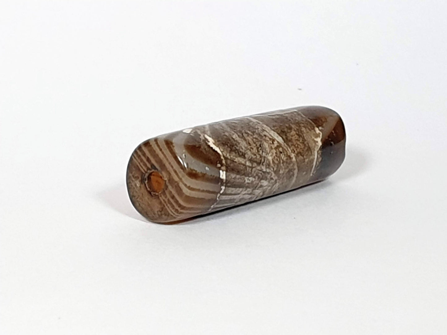 At-030420-1SNP, left end cap, off-centre drill hole, natural agate banding on end face, tobacco-brown body, unretouched