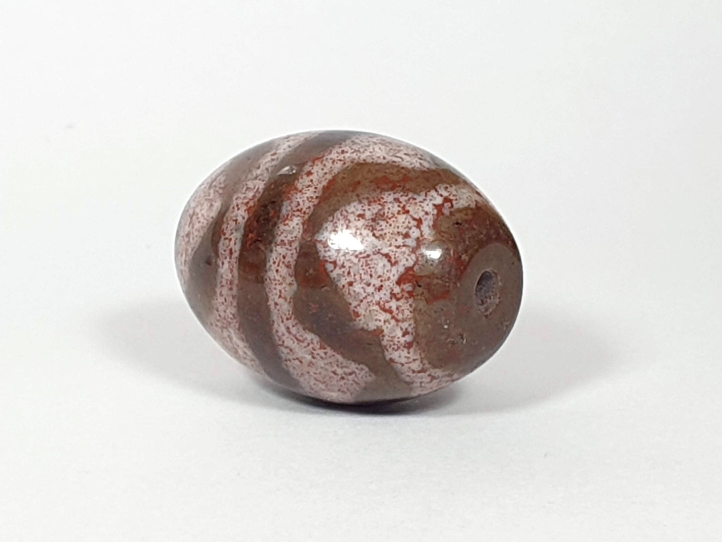 N-062926-TTBS2 Bead A, drill-end side view, dark chocolate-brown spherical agate, tiger tooth motif, bloodspots, unretouched