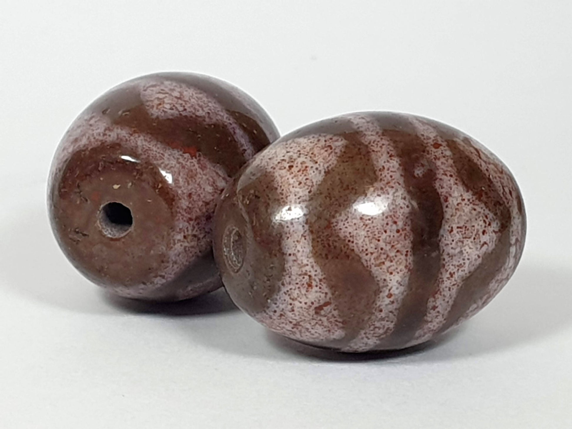 N-062926-TTBS2 pair shot, both beads, Bead A darker left, Bead B cream-ground right, tiger tooth motif, unretouched