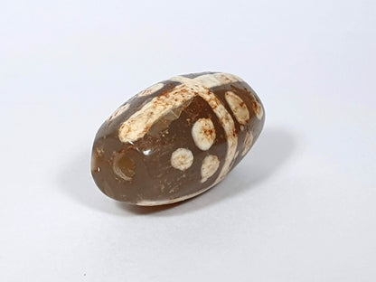 Ac-062426-18S Bead A angled view eighteen star motif medium warm brown agate ancient drill hole visible unretouched