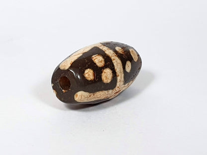 Ac-062426-18S Bead B end-on view large ancient drill hole deep dark warm brown ground unretouched