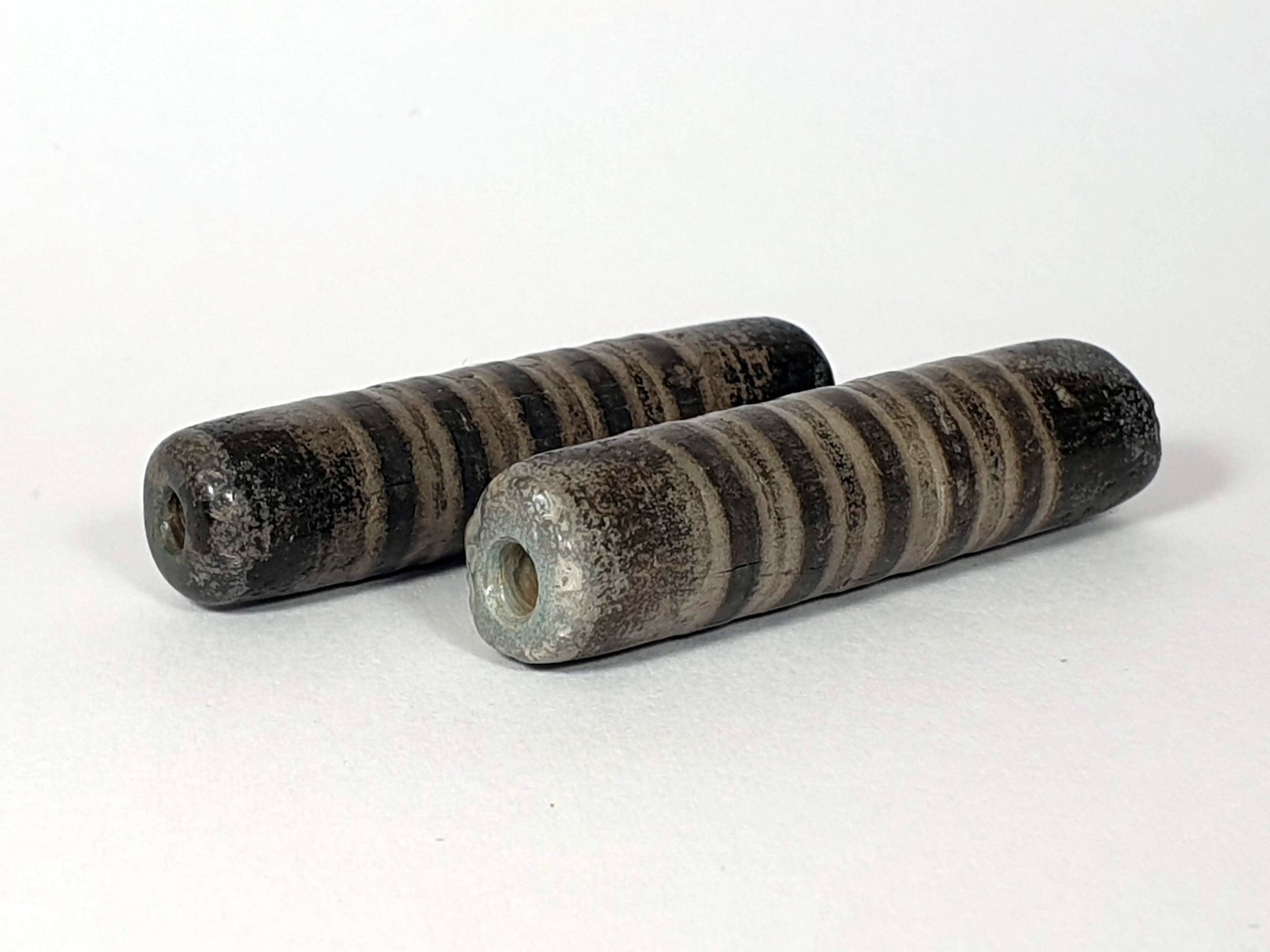 Ac-080420-19SChung, pair both beads, Bead A blue-green burial mineral deposit around drill hole, heavily weathered, unretouched