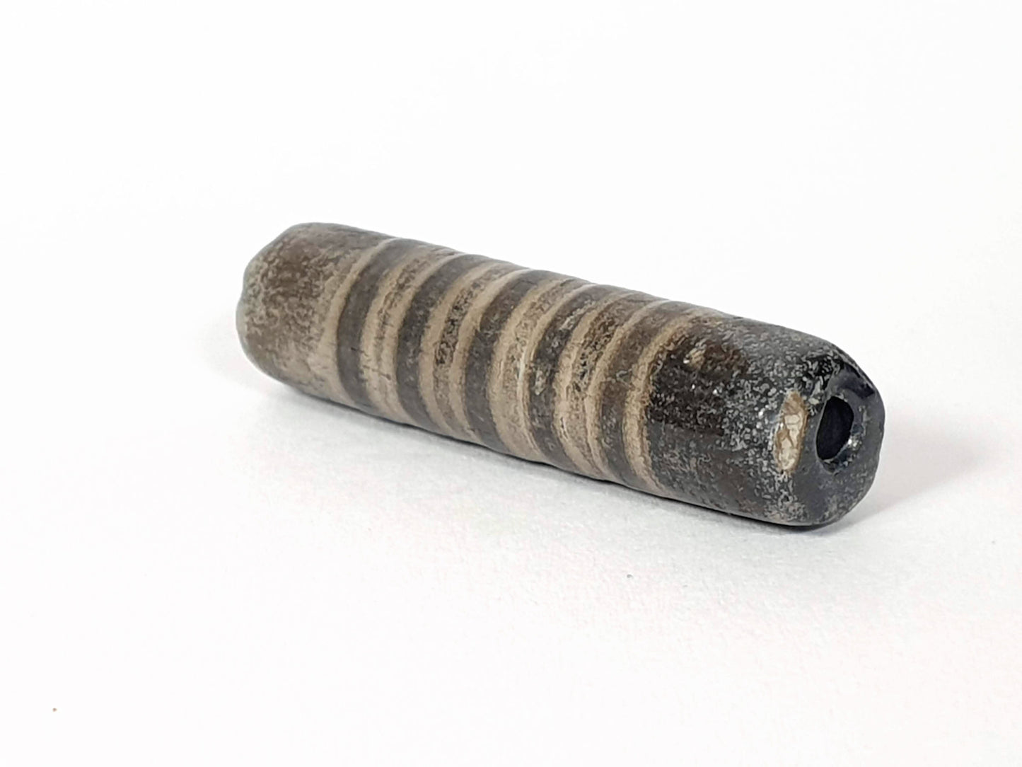 Ac-080420-19SChung, Bead A right end, large ancient drill hole with mineral deposit, encrusted end cap, unretouched