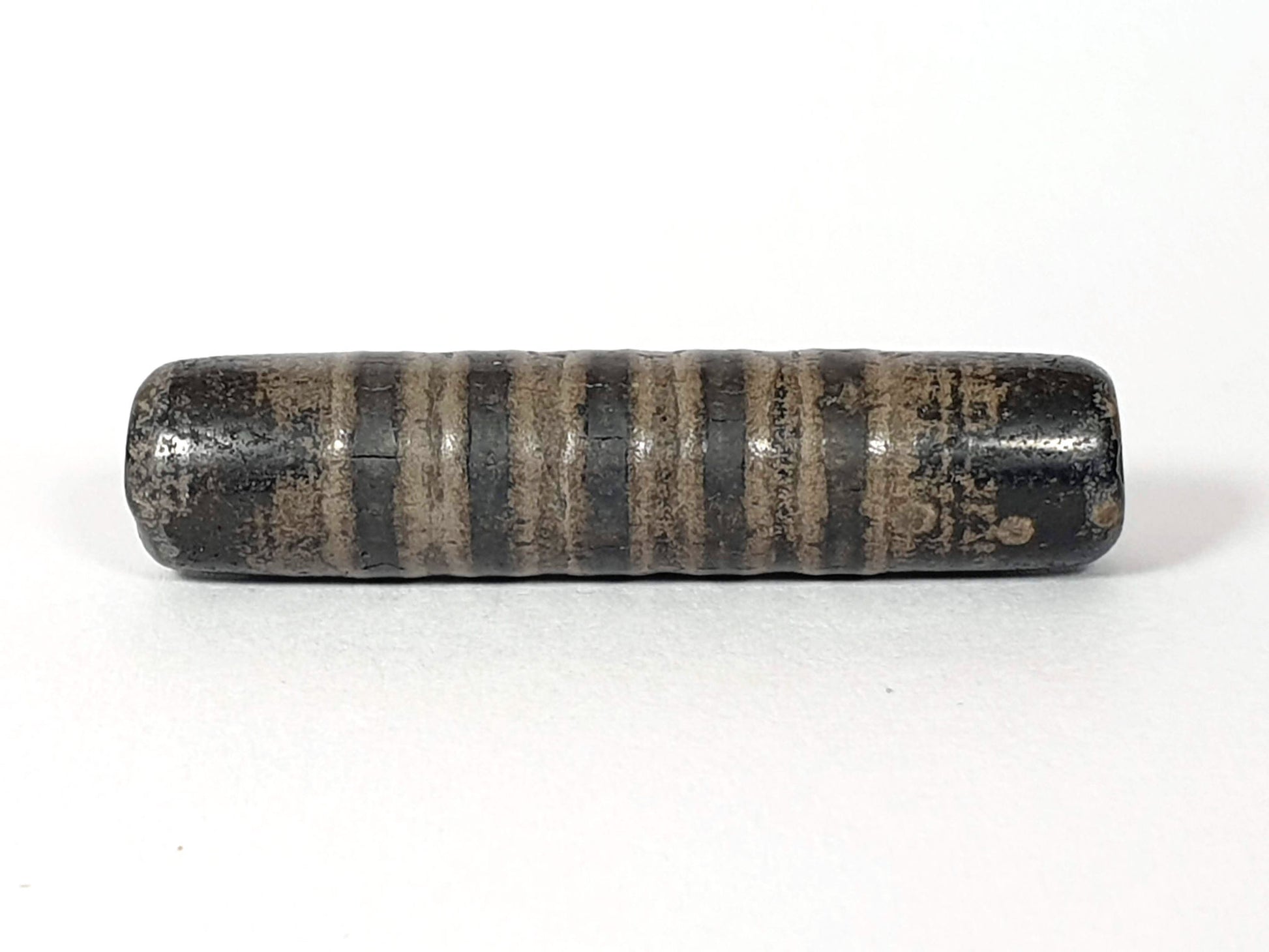 Ac-080420-19SChung, Bead B lateral, 19 stripe bands visible, matte pervasive weathering, white mineral spot disclosed, unretouched