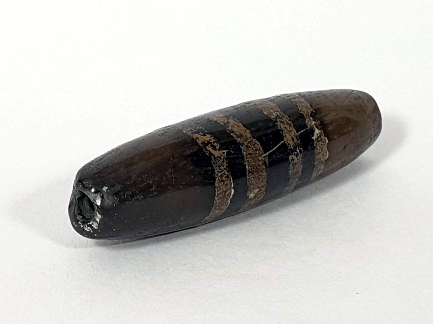Ac-080620-7SChung ancient Chung dzi, left end, near-pitch-black end cap darkening, drill hole intact, unretouched