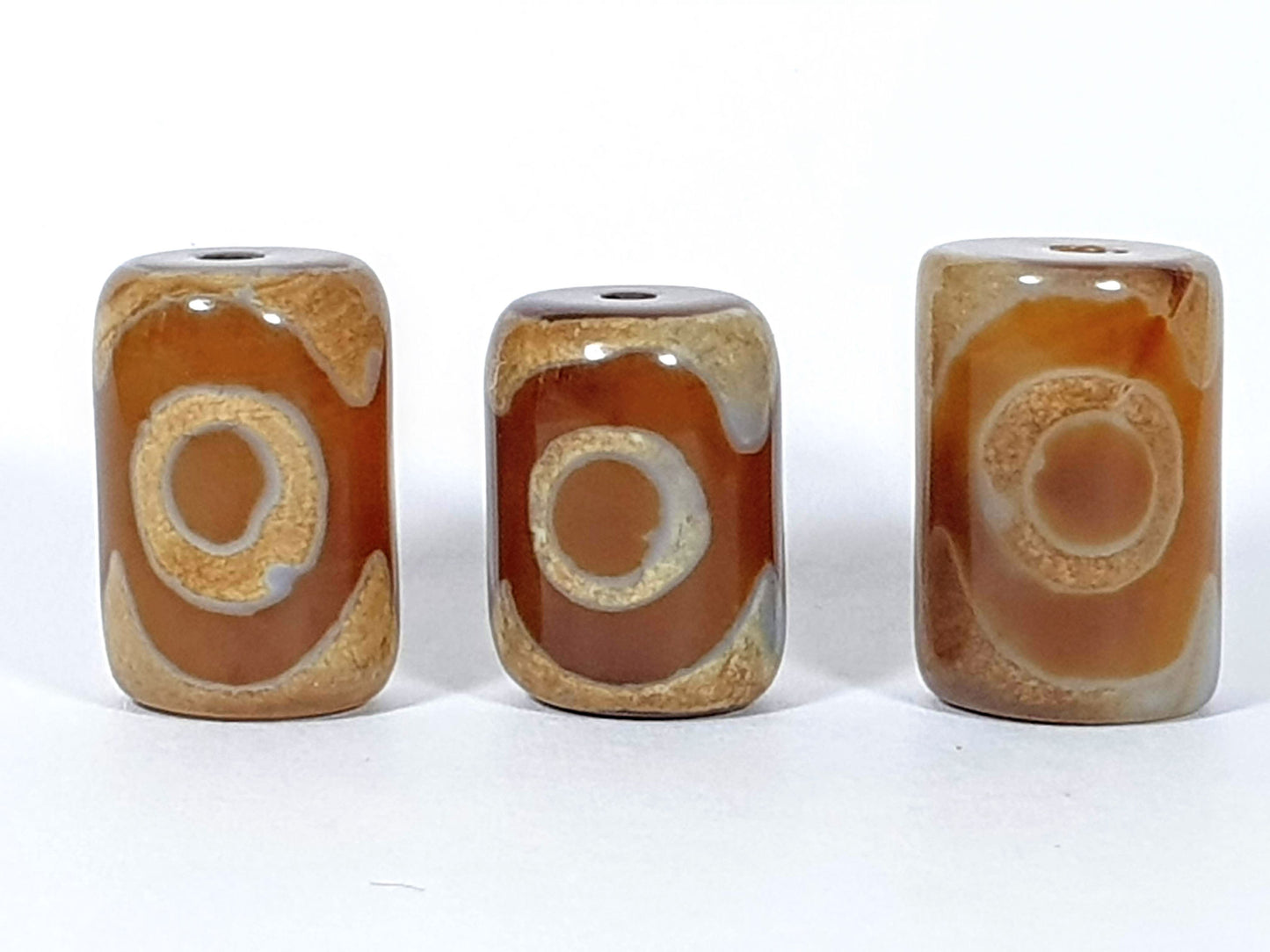 N-062626-3ESET set three new three eye dzi, second face view, eye ring construction visible, warm agate ground, unretouched