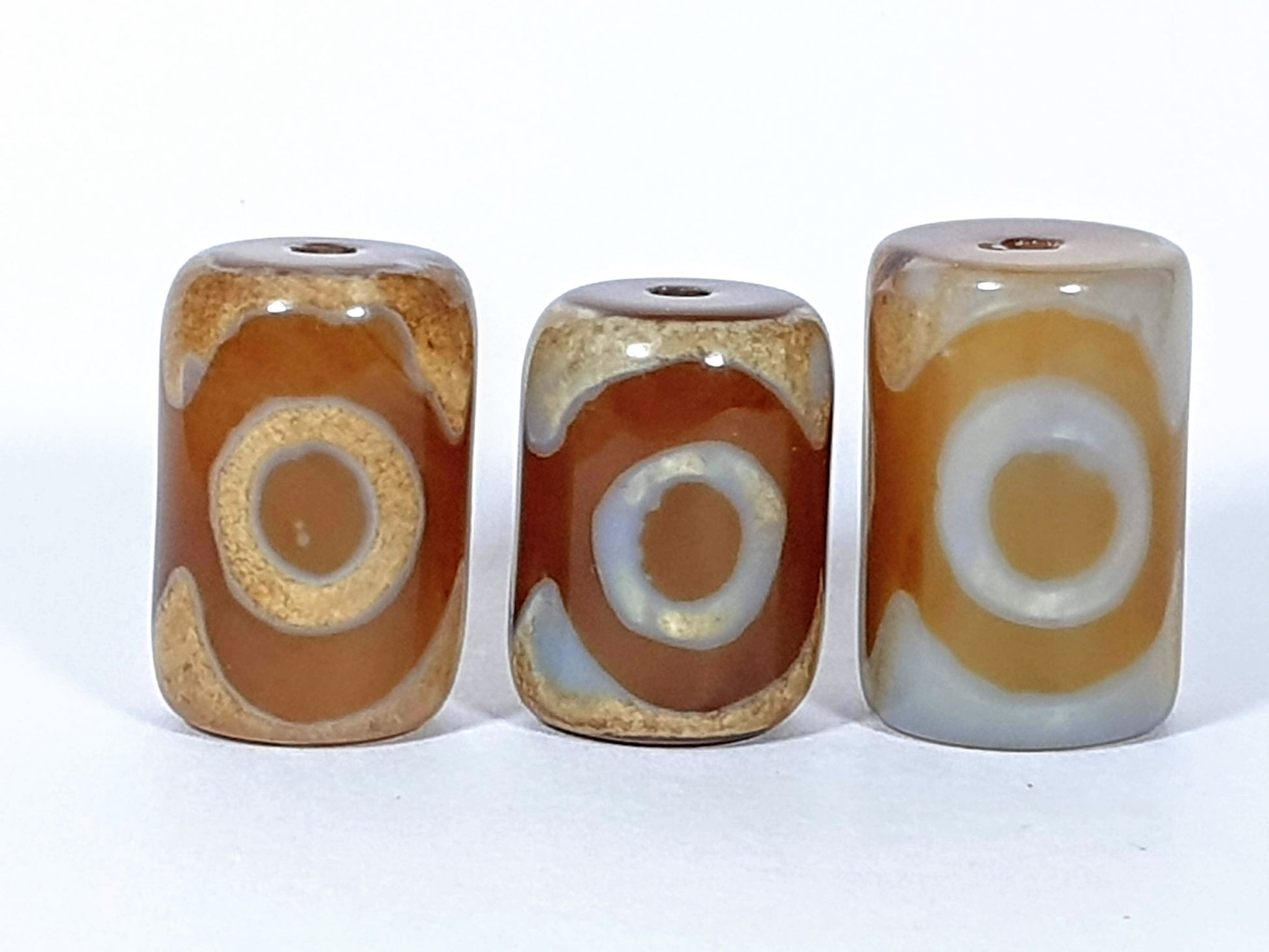 N-062626-3ESET set three new three eye dzi, third face view, grey-white accent banding visible right bead, unretouched