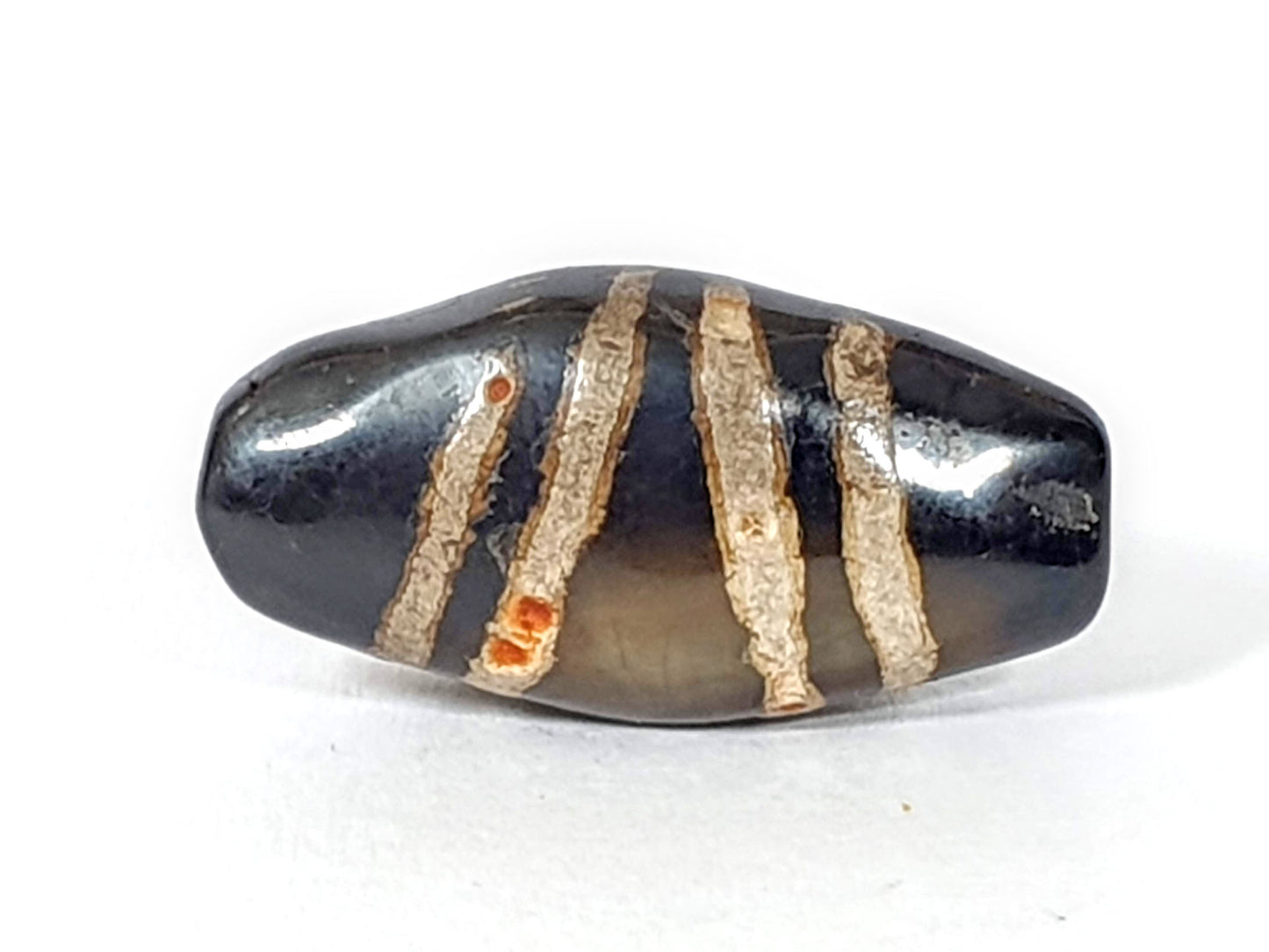 Face D broadest face, translucent grey centre zone, cinnabar clusters in beige stripes, unretouched