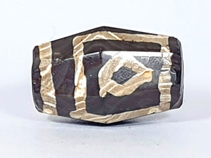 At-120120-2E7, antique octagonal two eye dzi, 21.8×12.1×14.4mm, deep dark-brown agate, raised cream etching, unretouched