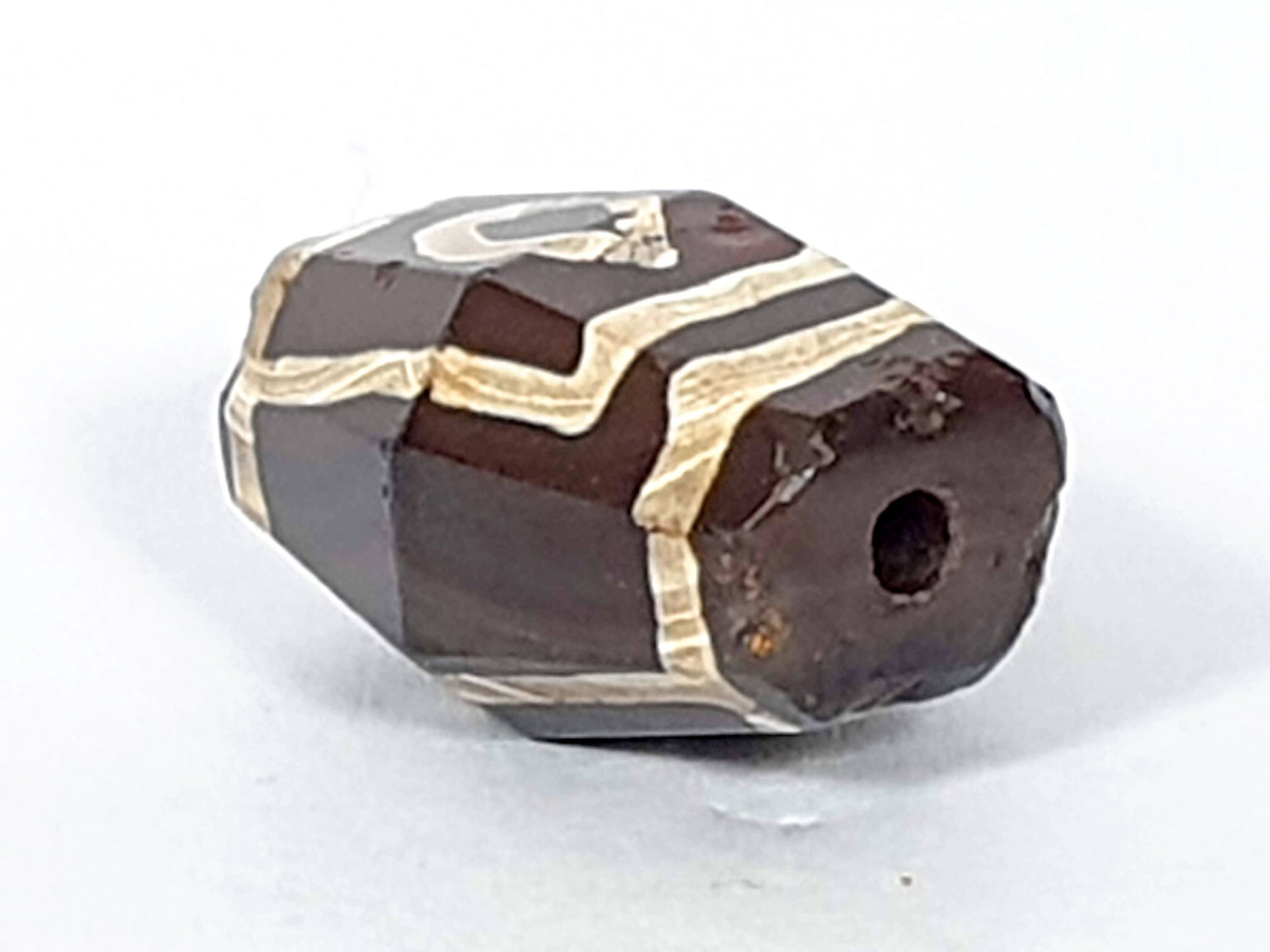 At-120120-2E7, octagonal end face with drilled hole, ancient weathering and oxidation around hole, unretouched