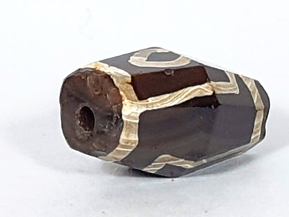 At-120120-2E7, opposite octagonal end face, ancient drilled hole, reddish oxidation, cream motif wrapping, unretouched