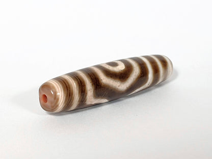 Qing Dynasty three eye dzi — angled end, drill hole at narrow tip, concentric arc stripes on cream-brown body, At-0426-3EQ