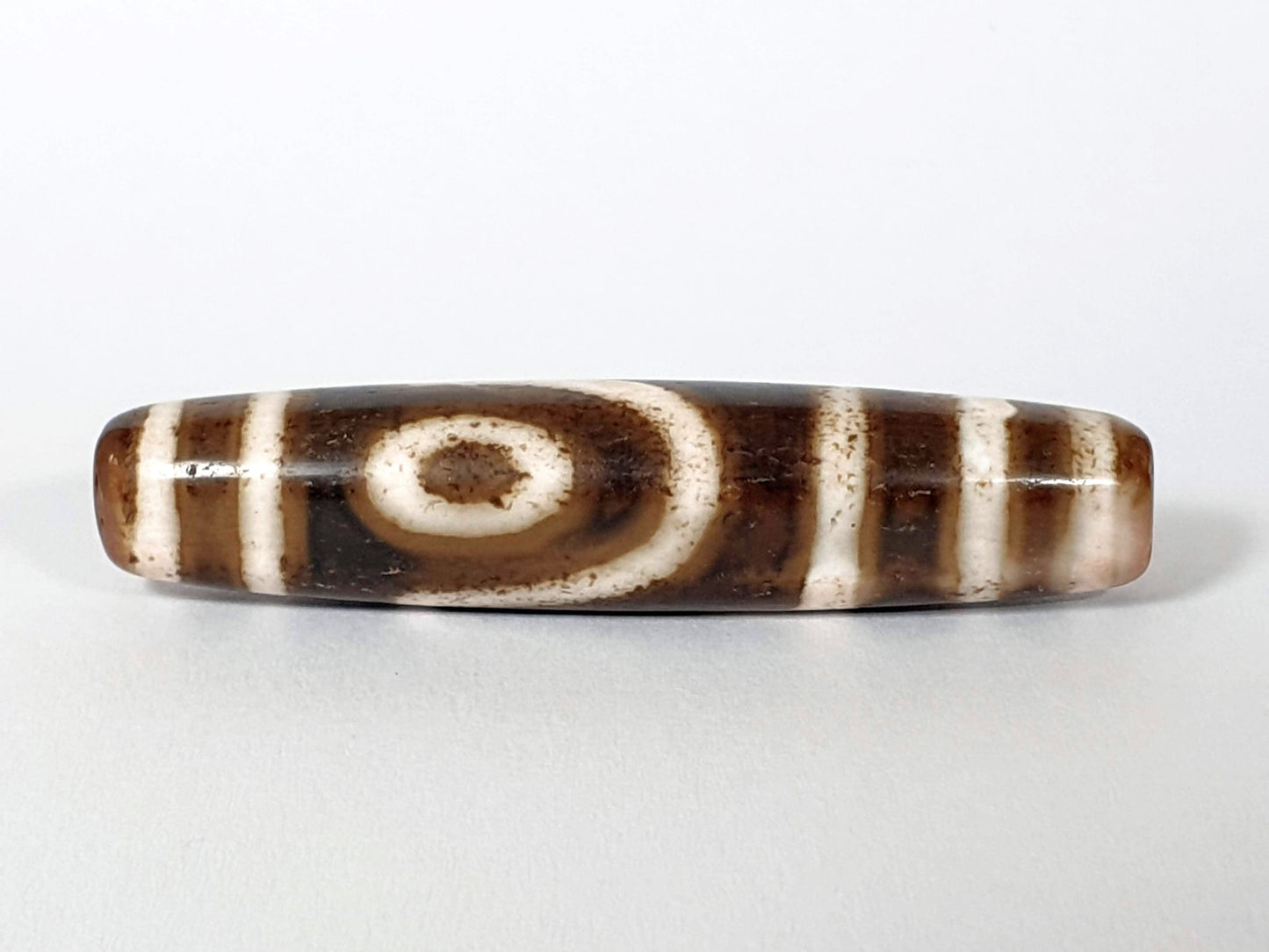 	Qing Dynasty two eye dzi — third face, second spiral eye on warm brown ground with pink-blush end, bracket bars, At-0426-2EQ