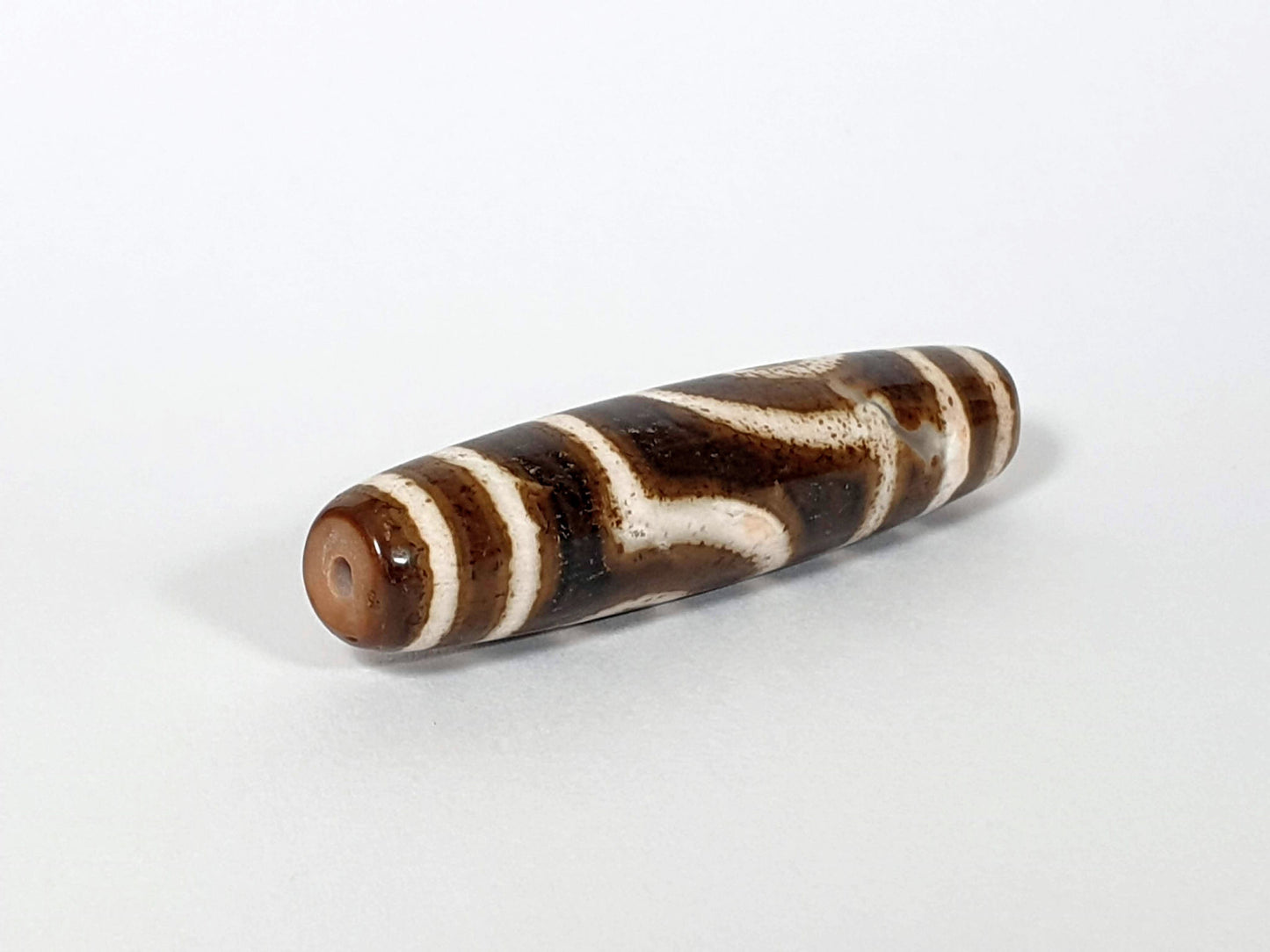 Qing Dynasty two eye dzi — opposite angled end, drill hole at warm brown left tip, dark brown cream stripe body, At-0426-2EQ