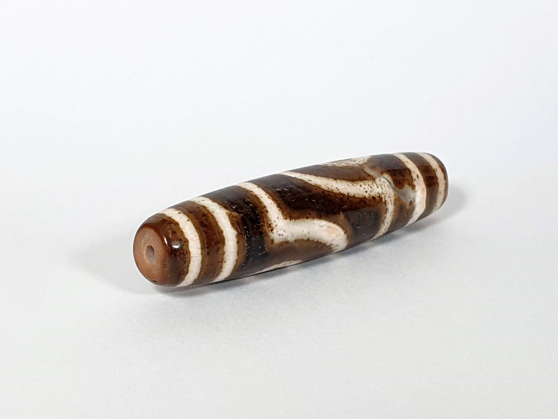 Qing Dynasty two eye dzi — opposite angled end, drill hole at warm brown left tip, dark brown cream stripe body, At-0426-2EQ