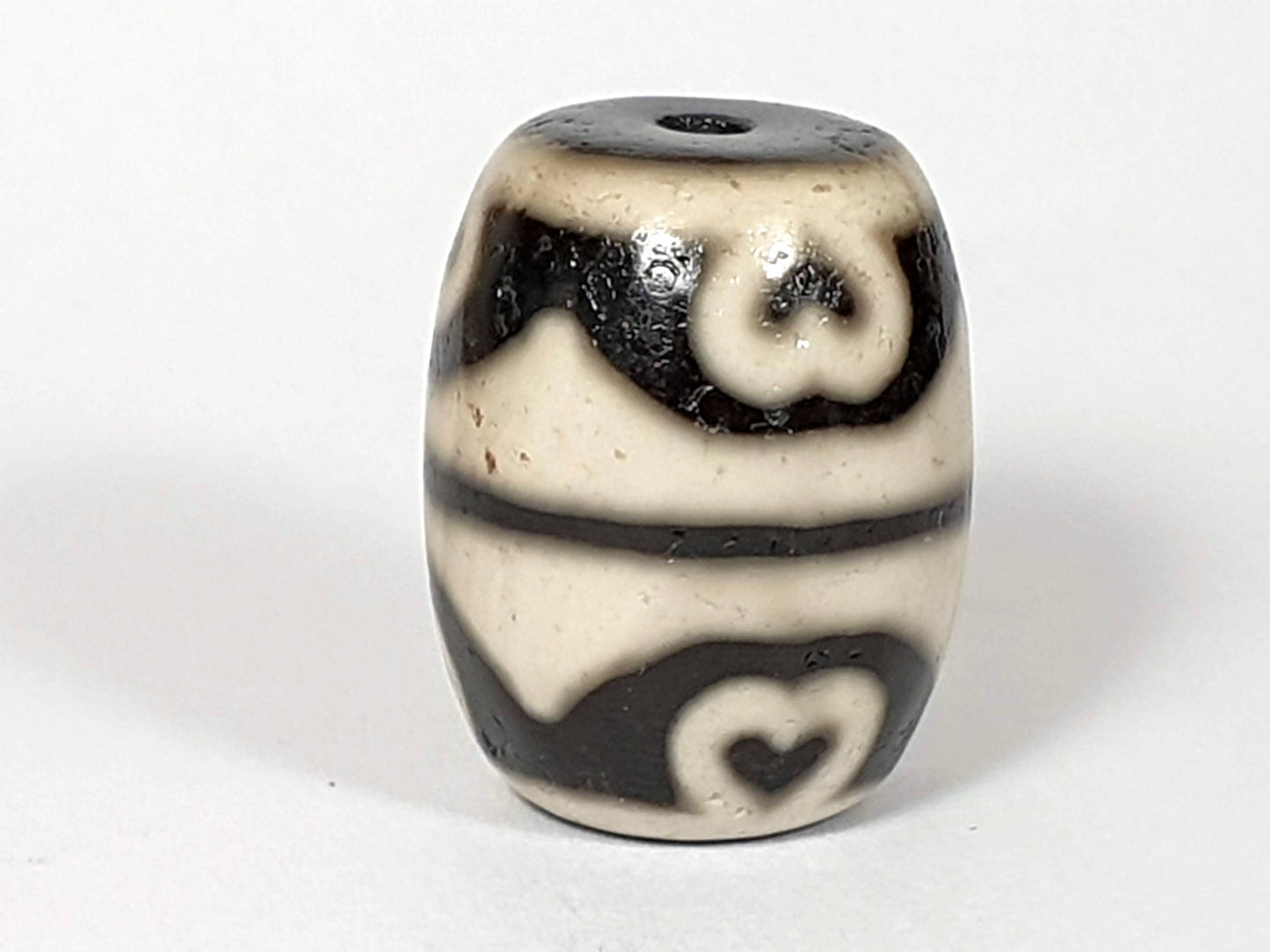 N-062226-TTSEL, upright face B, cream-ground barrel, scroll eye upper zone, heart tooth lower zone, dark brown, unretouched