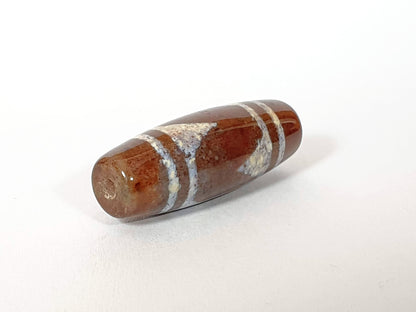N-062426-TTBS Bead A tiger tooth dzi 39.4x13.6mm opposite end warm reddish-brown agate natural striation unretouched