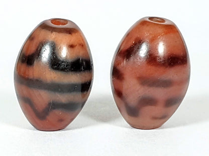 At-062926-TTBS pair top-down, drill holes visible, multifaceted crown profile both beads, warm terracotta agate, unretouched