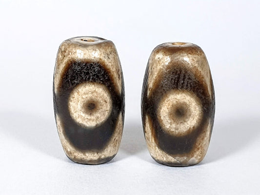 N-FA-062626-3E pair three eye agate dzi, front face, cream ground, 23.8×14.0 & 23.2×14.4mm, unretouched