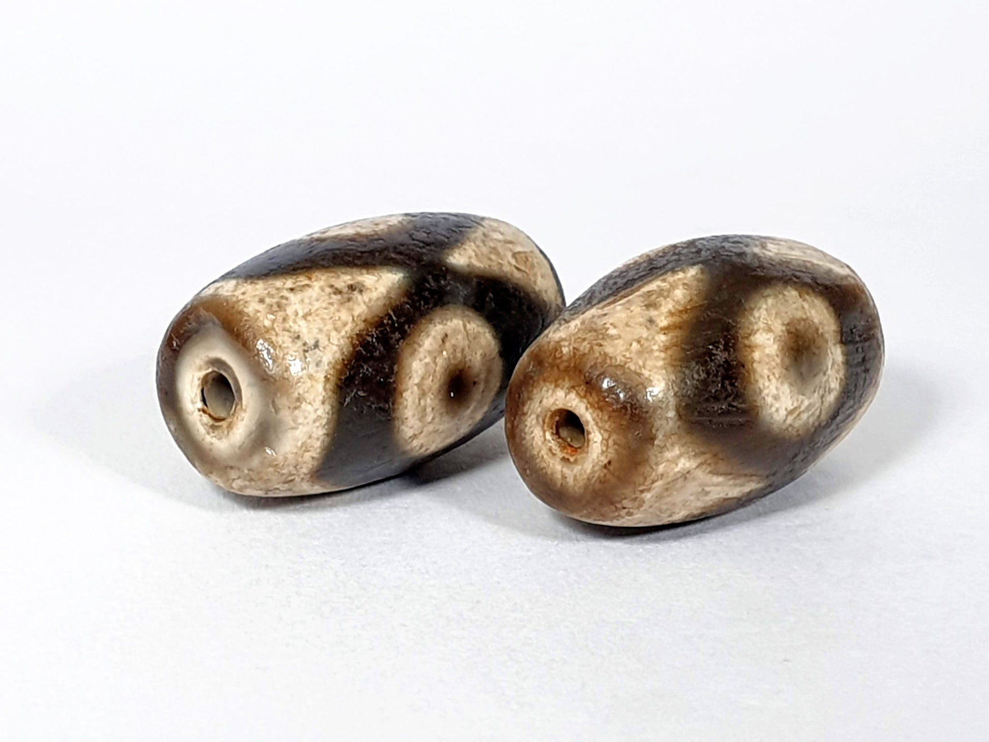 N-FA-062626-3E pair three eye agate dzi, side face view, two smaller eyes visible, chocolate-brown zones, unretouched