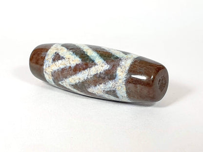 N-062426-3TSBS Bead B three stripe tiger dzi angled view cool blue-grey chevron motif dark brown ground unretouched