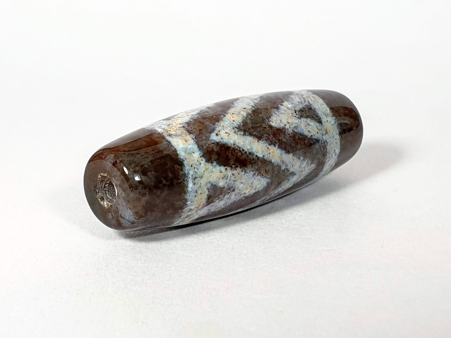 N-062426-3TSBS Bead B three stripe tiger dzi 39.6x13.8mm opposite end pale blue-grey motif drill hole unretouched