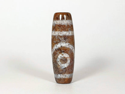 N-062126-2E dzi bead, standing end view showing drill hole detail, unretouched
