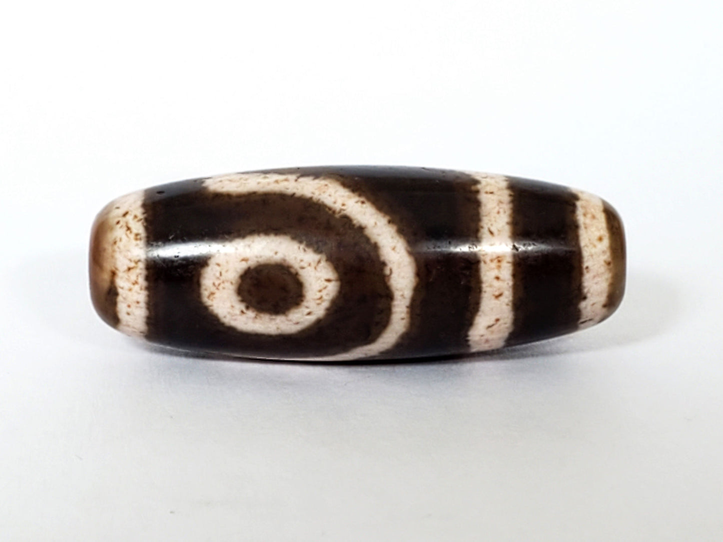 Qing Dynasty two eye dzi — second face, spiral eye, bracket bars, granular cream zones, drill hole at tip, At-0426-2EQ2