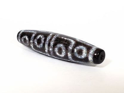 N-062126-12E-2 dzi bead, close side profile, visible surface speckling, unretouched