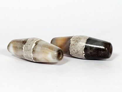 Ac-061526-1SPair, both beads showing tip drill holes, Bead A pale ground, Bead B dark ground, contrasting pair, unretouched