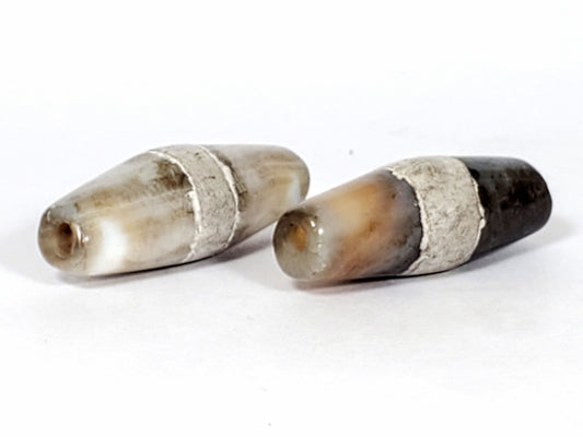 Ac-061526-1SPair, both beads opposite tips, Bead B warm honey-orange tip contrasting dark body, calcification zones, unretouched