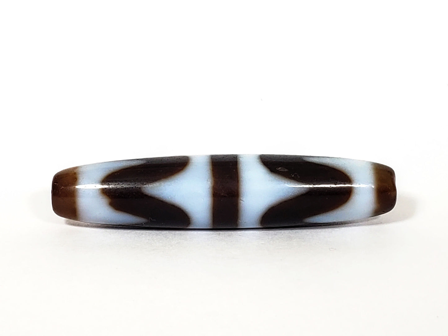 N-062226-DW3, face B, very deep dark brown agate, bilateral wave forms flanking central bar, cool white field, unretouched