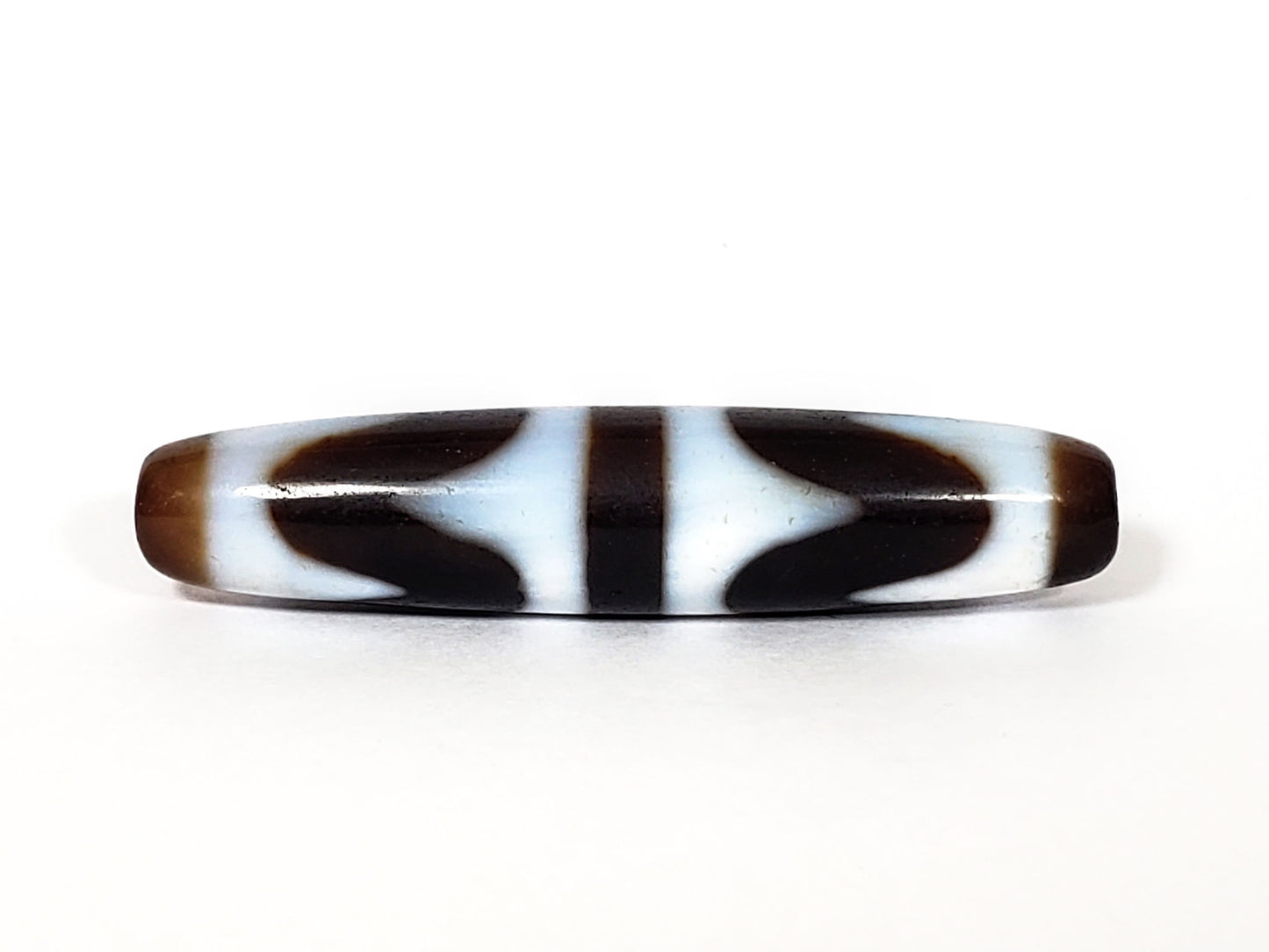 N-062226-DW3, face C, sharp wave forms, very dark brown ground, cool white etched field, symmetric fusiform, unretouched