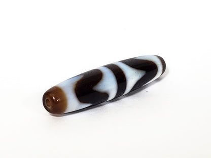 N-062226-DW3, opposite end cap, warm honey-brown, drill hole centred, cool white wave forms wrapping body, unretouched