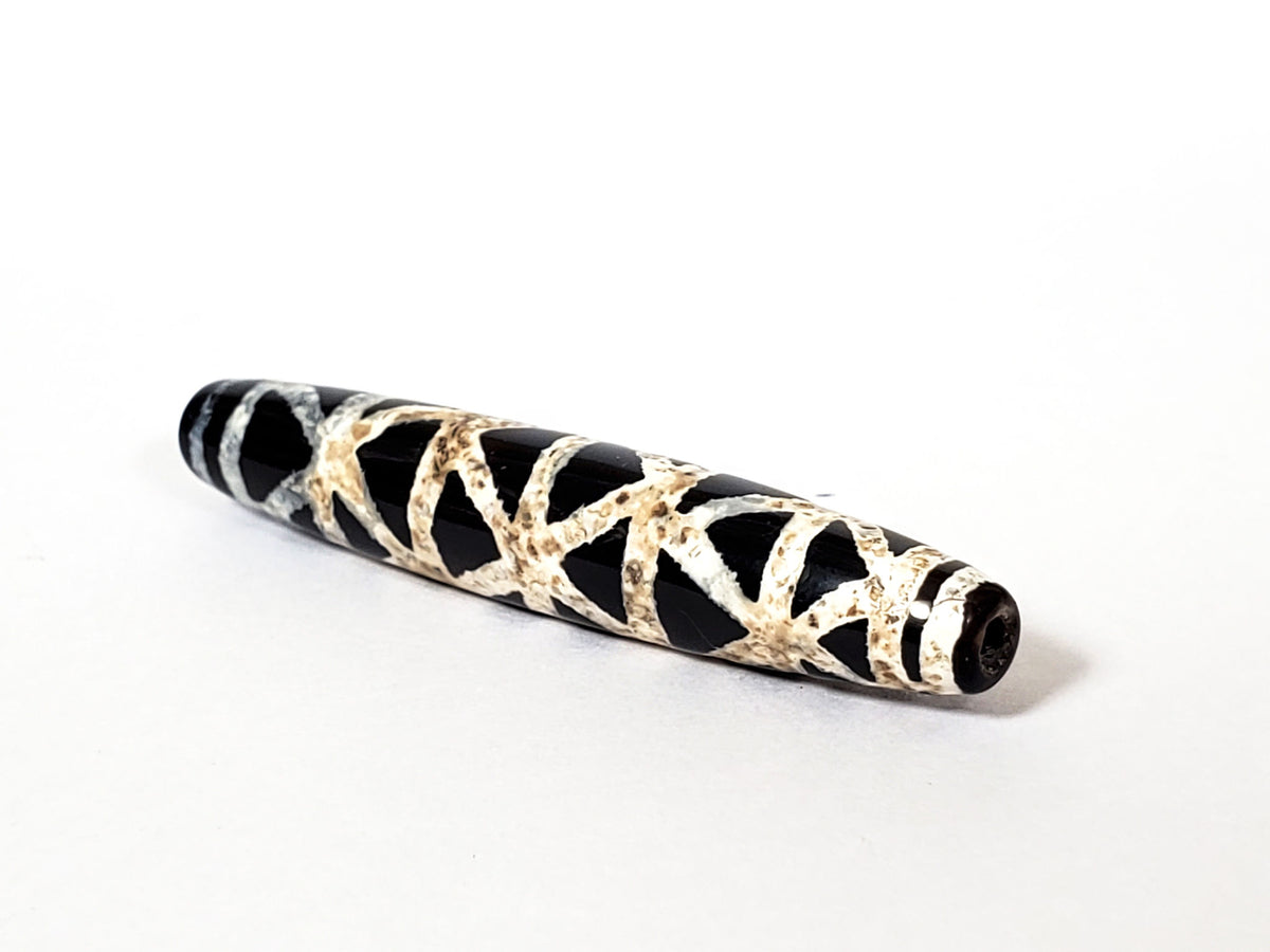 Ancient criss-cross motif carnelian dzi beads with black and white striped agate patterning and visible drill holes